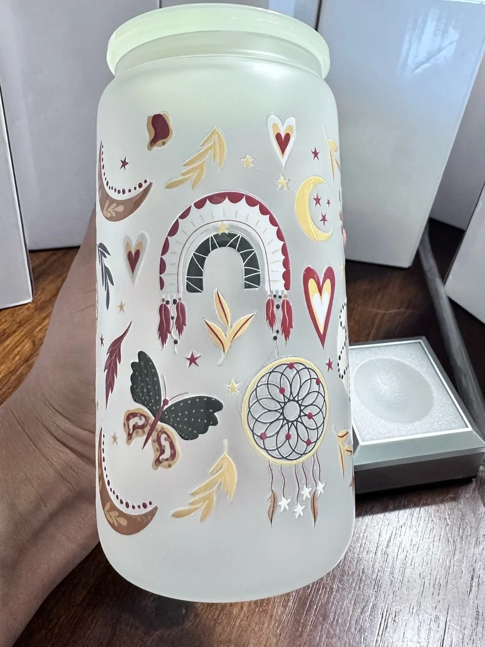 Glass tumbler with a dreamcatcher, rainbow, and butterfly design.